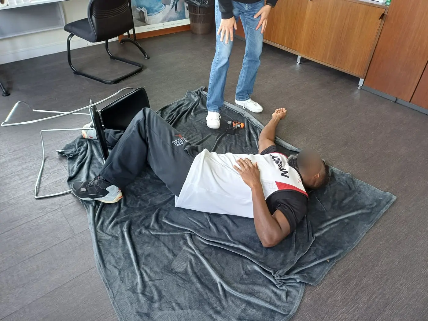Mise en situation d'un apprenant au sol après une chute de hauteur lors d'une formation SST.