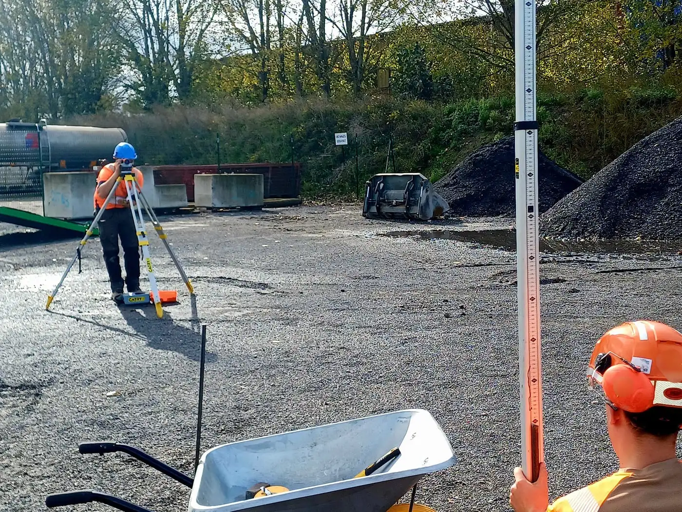 Apprenant utilisant une lunette de chantier lors d'une formation en topographie.